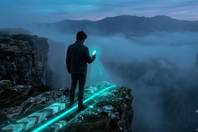 Eine Aufnahme von hinten (Rückenansicht) einer Person, die am Rand einer imposanten Klippe steht oder auf eine kopfsteingepflasterte, im Nebel verschwommene Straße blickt. Sie hält ein Smartphone in der Hand. Der Bildschirm des Telefons leuchtet in einem intensiven Türkiston und projiziert eine helle digitale Linie oder transluzente Vektorpfeile (im Stil einer digitalen Benutzeroberfläche) auf den Boden, die genau den Weg markieren, den ihre Füße gerade beschreiten. Hochkontrastierter filmischer Realismus, atmosphärische und dichte Lichtstimmung.