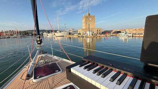Sintonía sobre el agua: el piano de Francisco Álvarez enmarca la silueta de la Torre de Control durante el recital al atardecer en Puerto Sotogrande.