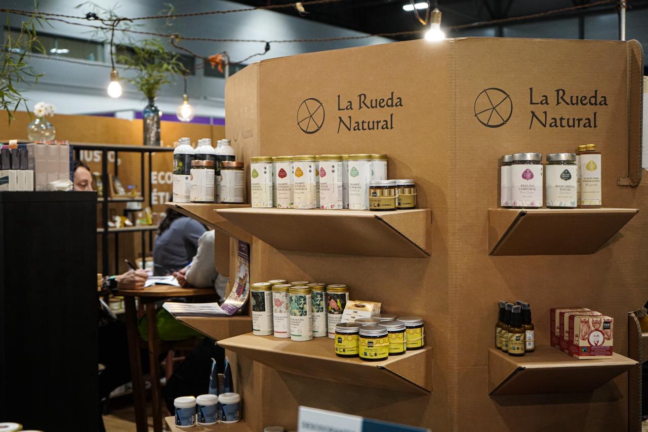 Coherencia en cada espacio: expositores de cartón reciclable y productos de cosmética certificada que integran la Economía del Bien Común en toda la cadena de valor.